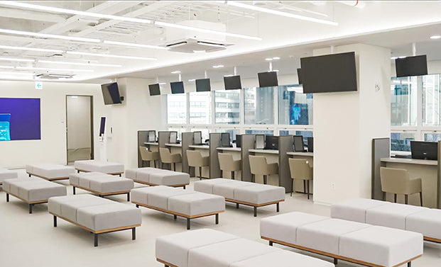 Waiting area at the KMI Gwanghwamun Center with self check-in kiosks and windows onto the city