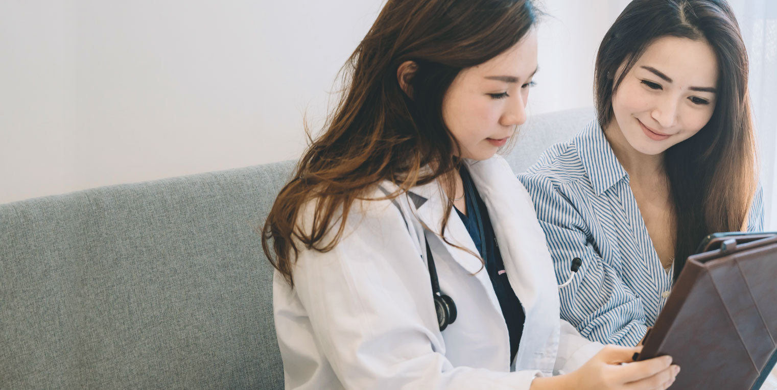 doctor with a patient reviewing a positive analysis report.