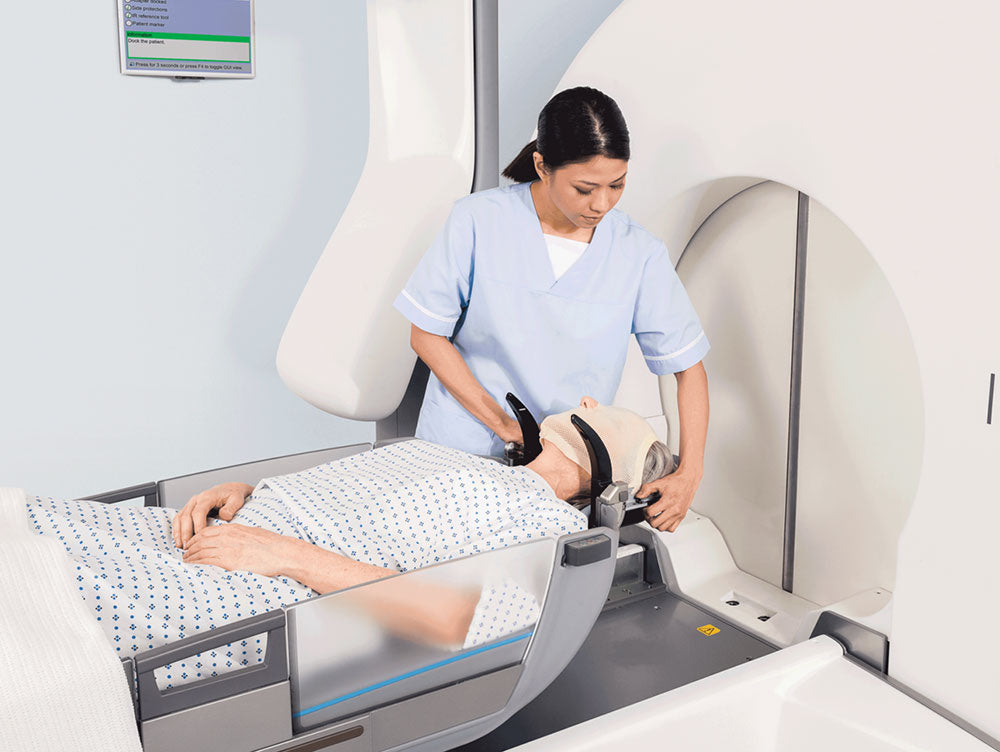 Patient in bed before a body scan with nurse helping the head adjustments.