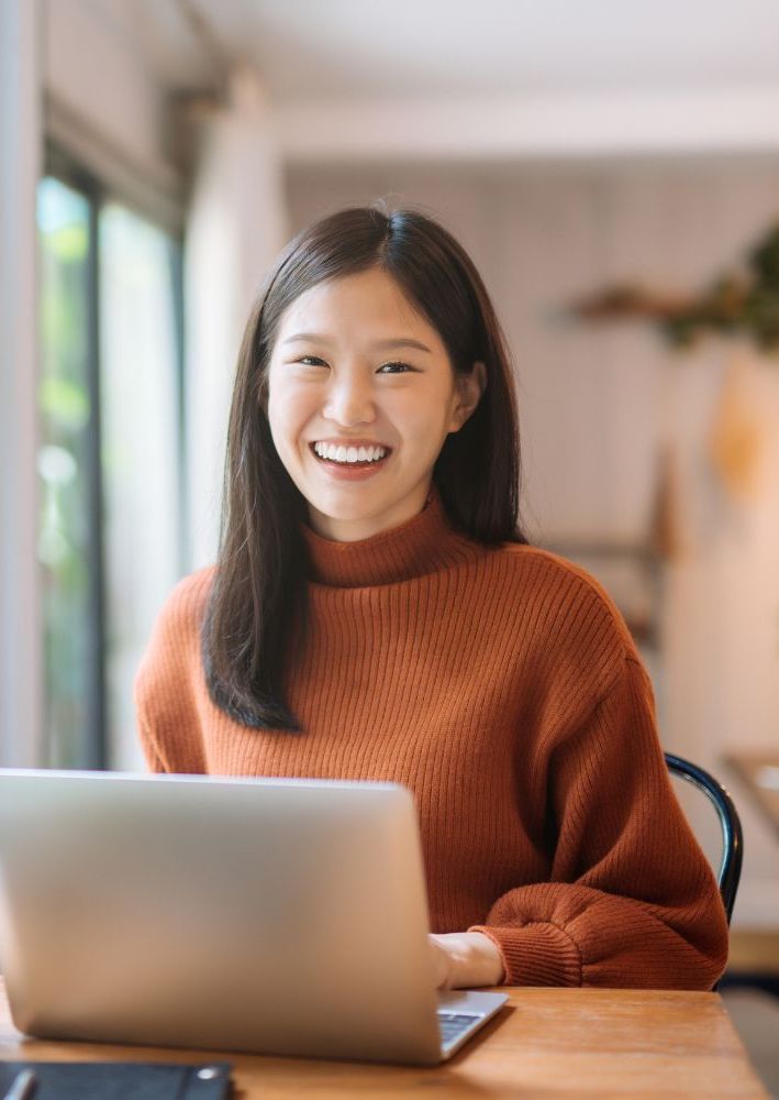 female smiling while leaving a positive review.