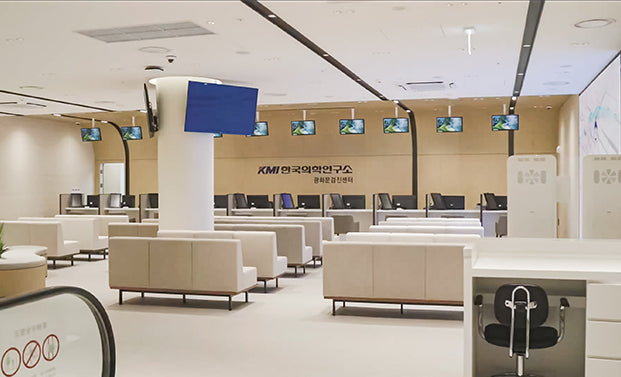 Check-in hall at the KMI Gwanghwamun Center, with reception counters beneath the center's signage